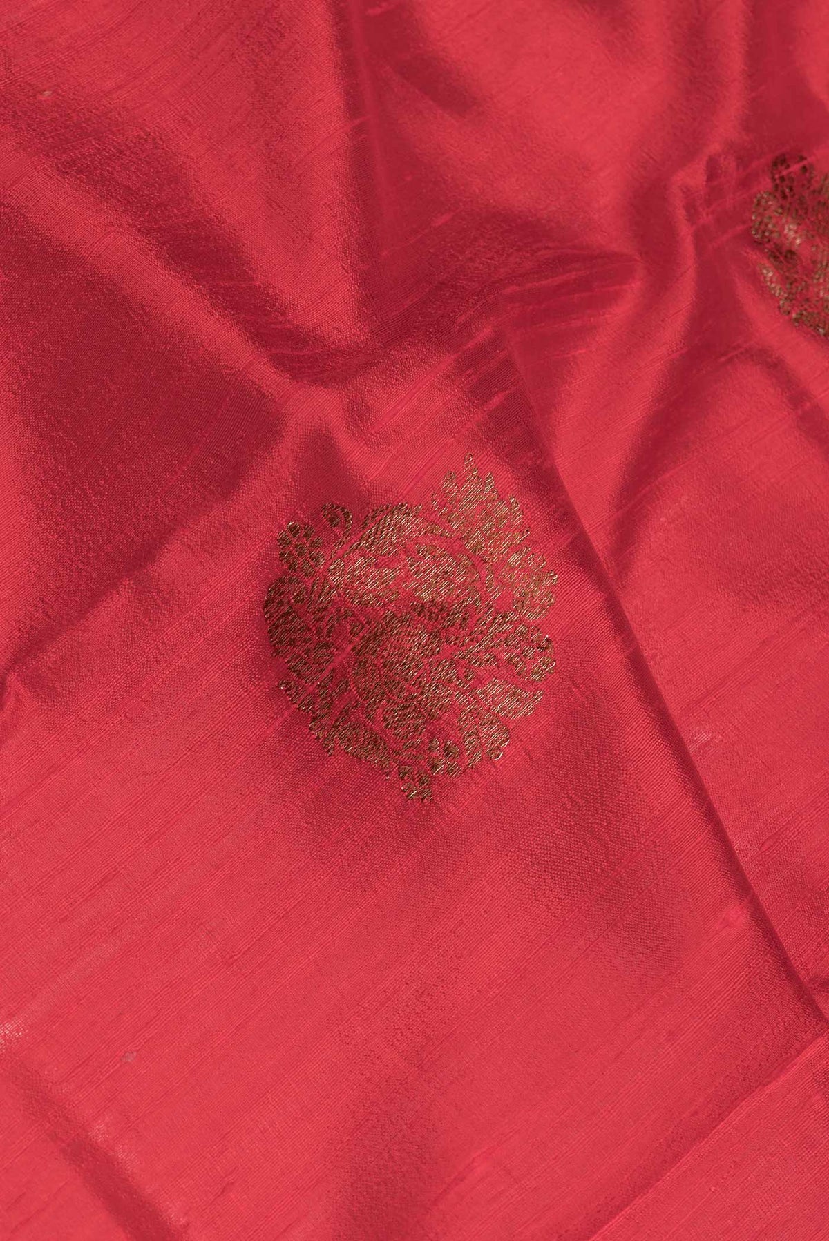 Close up of Red Dual Tone Tussar Saree with Zari Butta on the body and Zari And Thread Border.  displaying folds