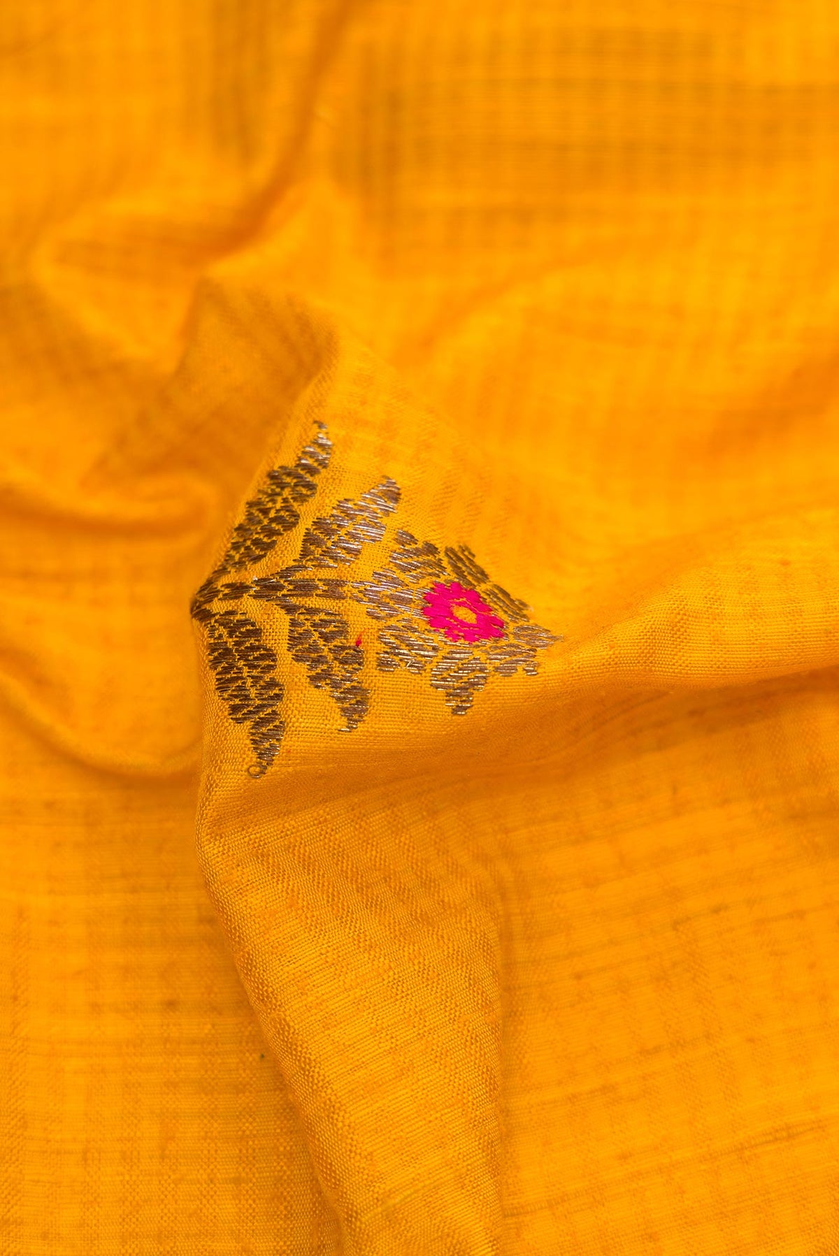 Close up of Yellow Banarasi Tussar Silk Saree with Zari And Thread Butta on the body and Zari Border displaying folds