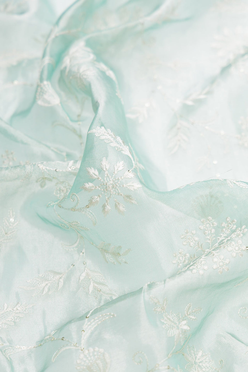 Close up of Sea Green Dual Tone Organza Silk Saree with Embroidery on the body and Embroidery Border.  displaying folds