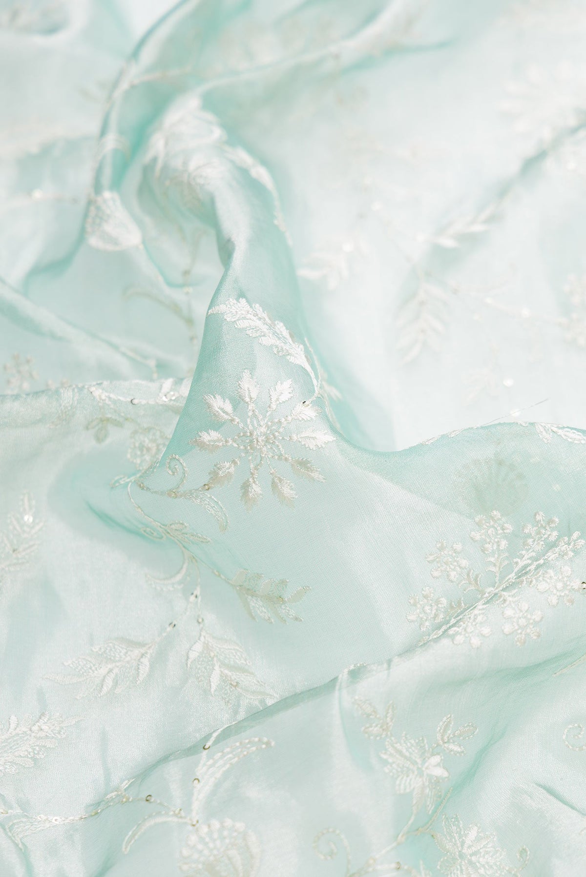Close up of Sea Green Dual Tone Organza Silk Saree with Embroidery on the body and Embroidery Border.  displaying folds
