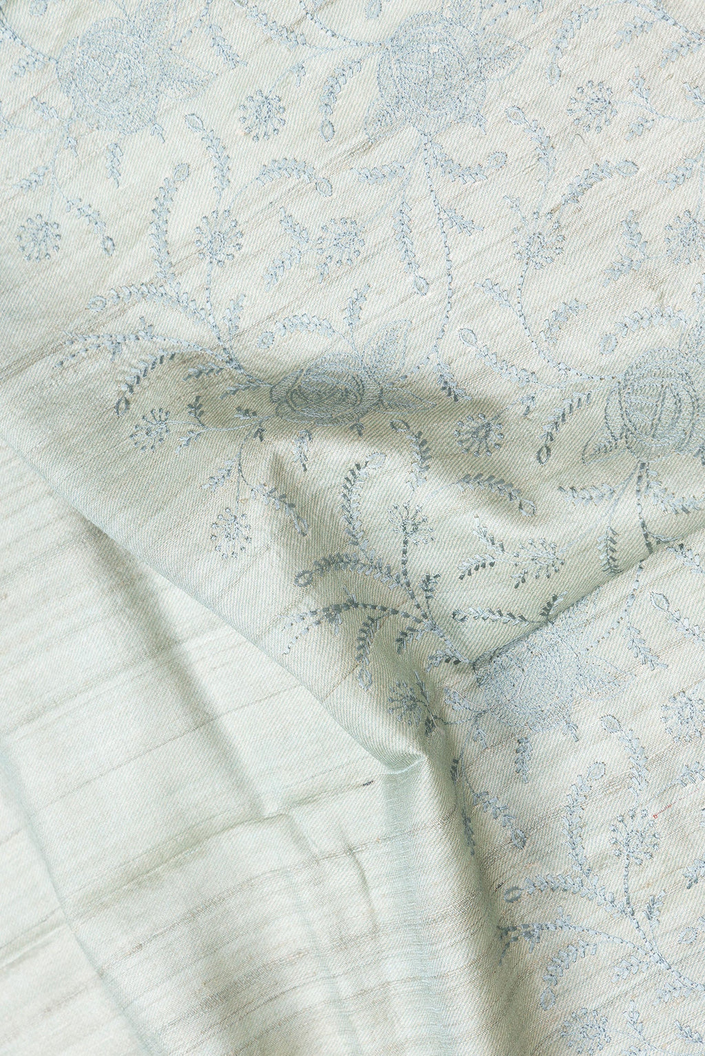 Close up of Sea Green Dual Tone Tussar Silk Saree with Embroidery on the body and Printed Border.  displaying folds