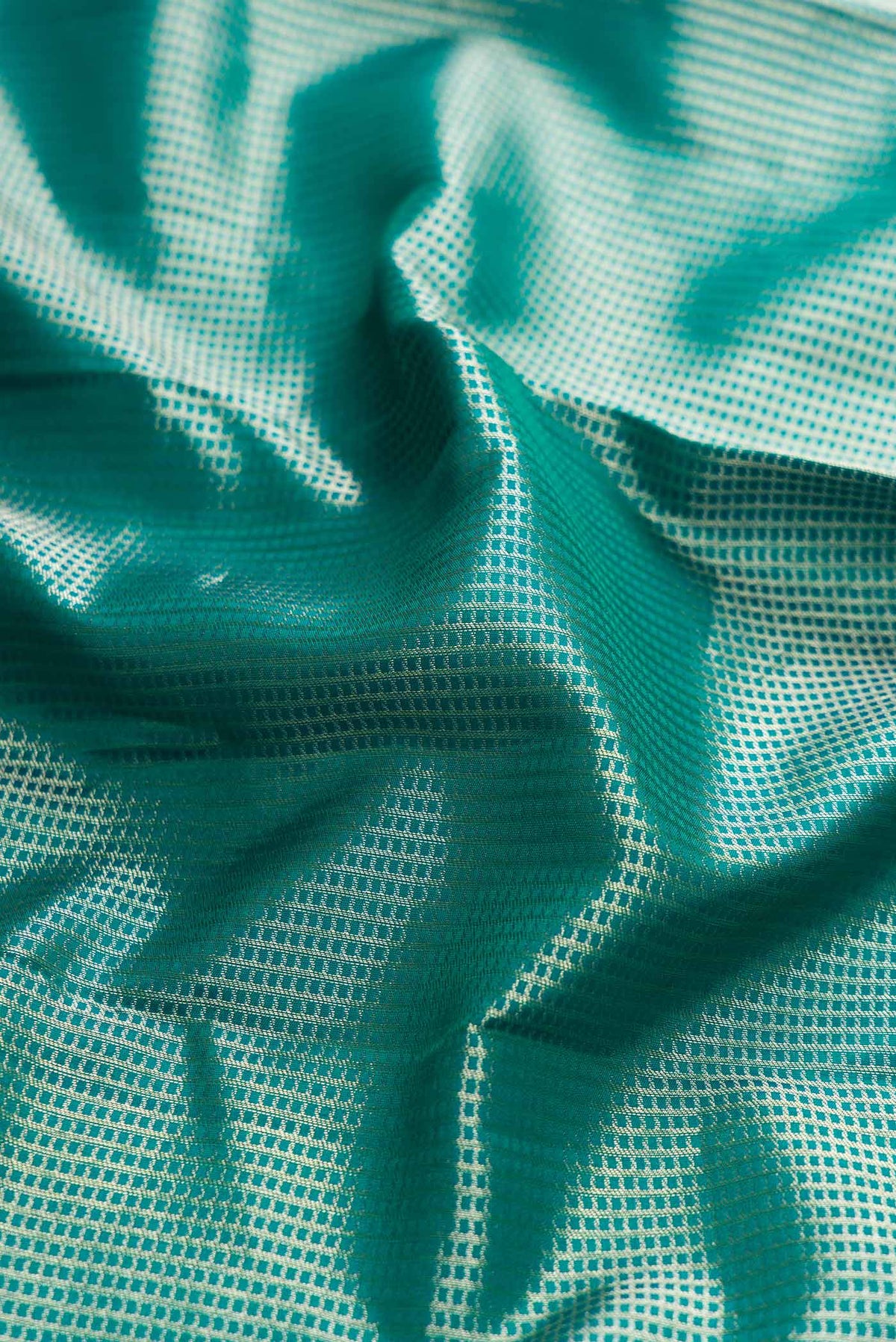 Close up of Peacock Blue Dual Tone Kanchipuram Silk Saree with Zari Brocade on the body and Fancy Border displaying folds