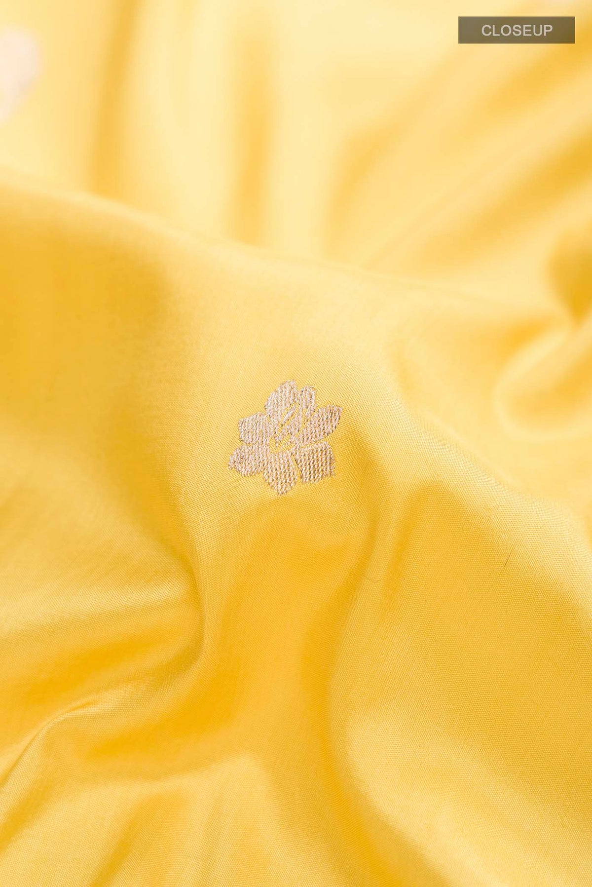 Close up of Yellow Banarasi Silk Saree with Zari Butta on the body and Zari Border displaying folds