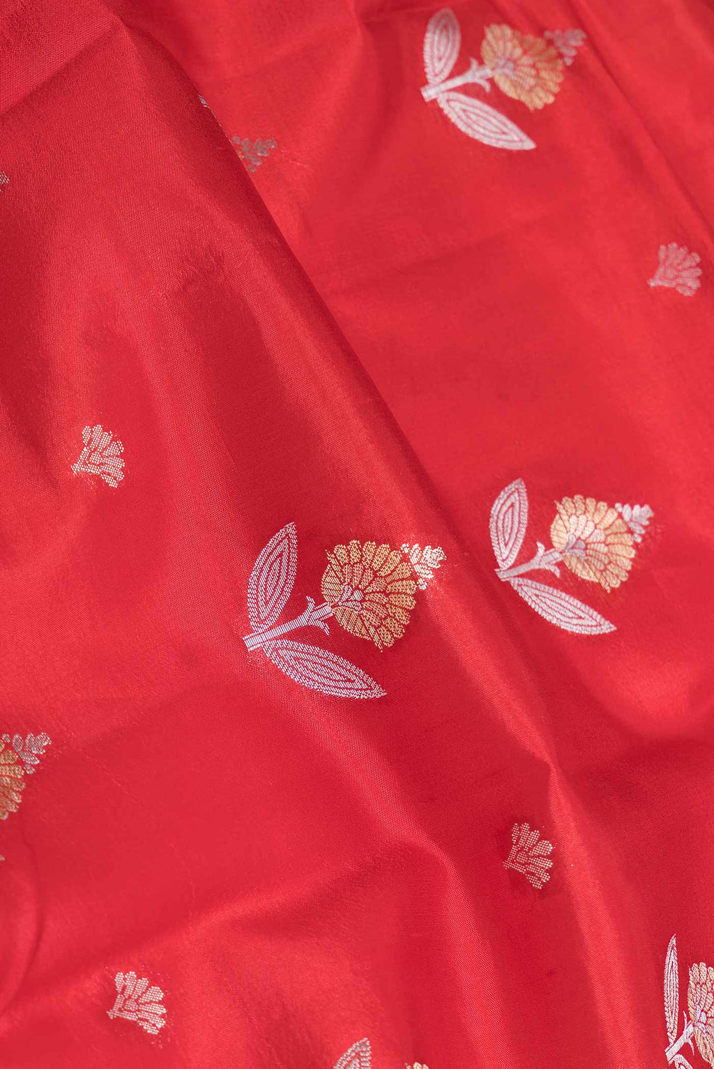 Close up of Red Banarasi Raw Silk Saree with Zari Butta on the body and Zari Border displaying folds