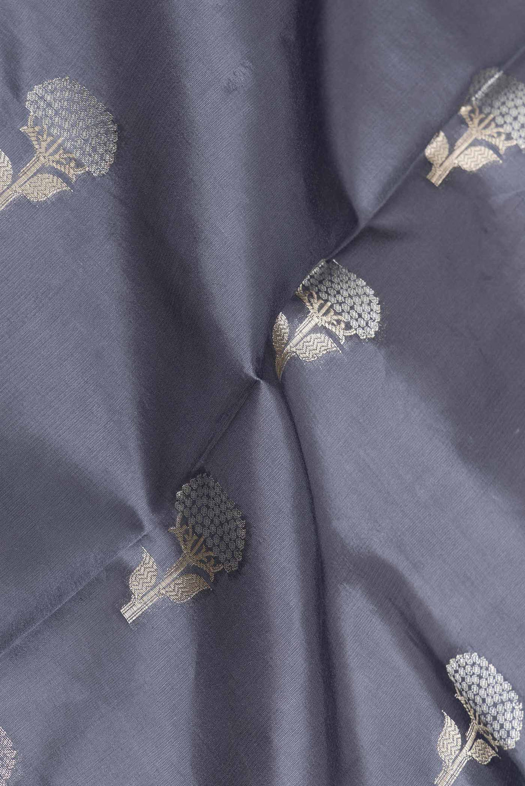 Close up of Grey Banarasi Raw Silk Saree with Zari Butta on the body and Zari Border displaying folds