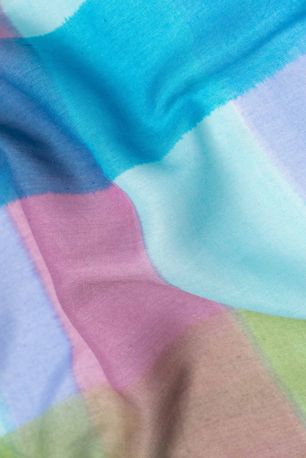 Close up of Sky Blue, Pink and Green Color Tussar Silk Saree with Printed design on the body and Zari Border displaying folds