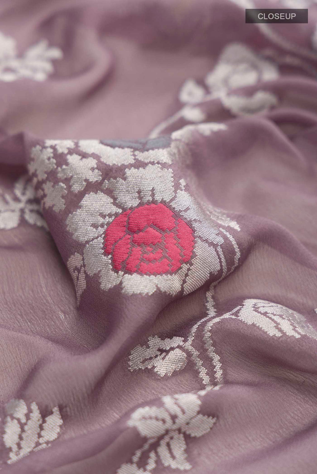 Close up of Lilac Banarasi Georgette Saree with Zari Butta on the body and Zari Border displaying folds