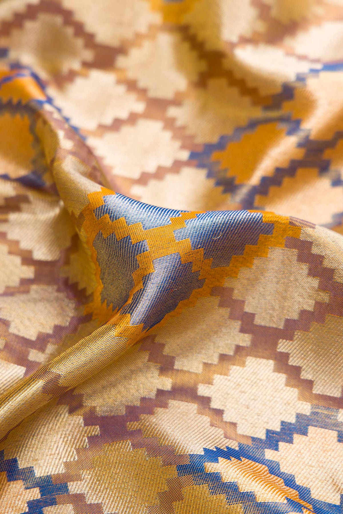 Close up of Gold Dual Tone Kanjivaram Tissue Silk Saree with Zari Brocade on the body and Zari Border.  displaying folds