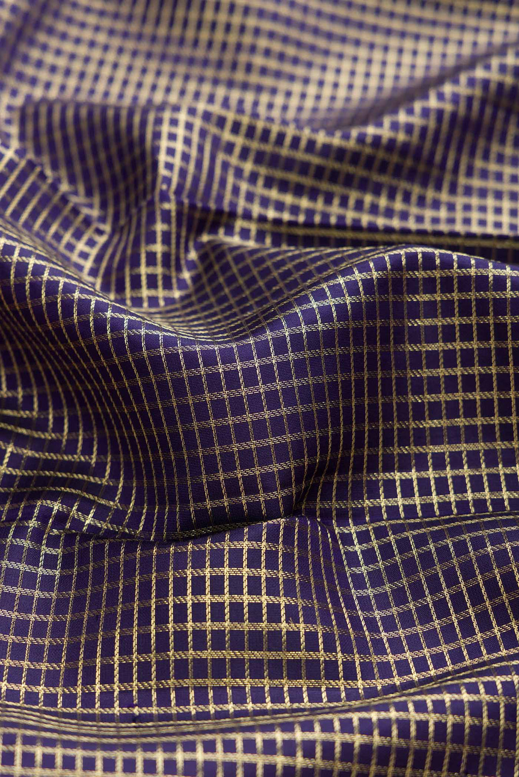 Close up of Navy Blue Dual Tone Kanchipuram Silk Saree with Checked design on the body and Zari Border displaying folds