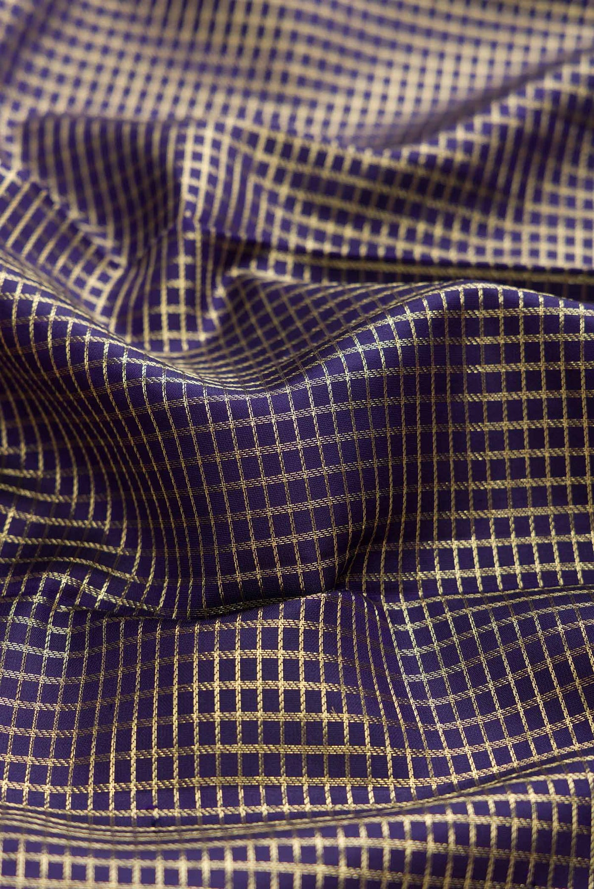 Close up of Navy Blue Dual Tone Kanchipuram Silk Saree with Checked design on the body and Zari Border displaying folds