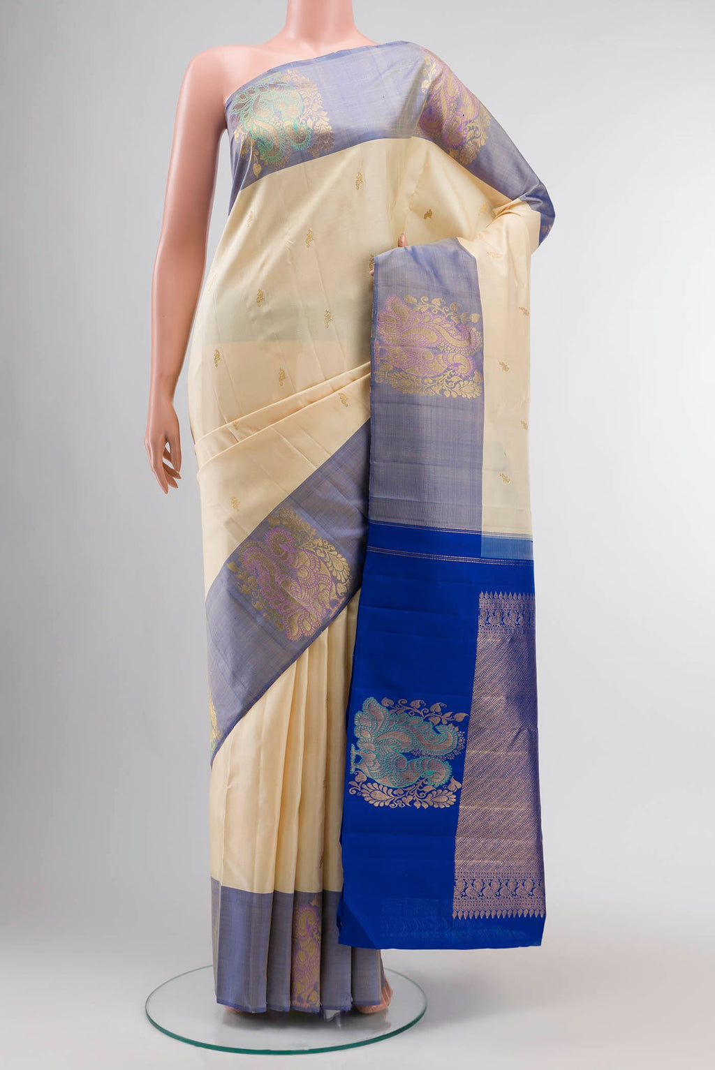 Cream Kanchipuram Silk Saree with Zari Butta on the body and Zari Border displayed on a mannequin