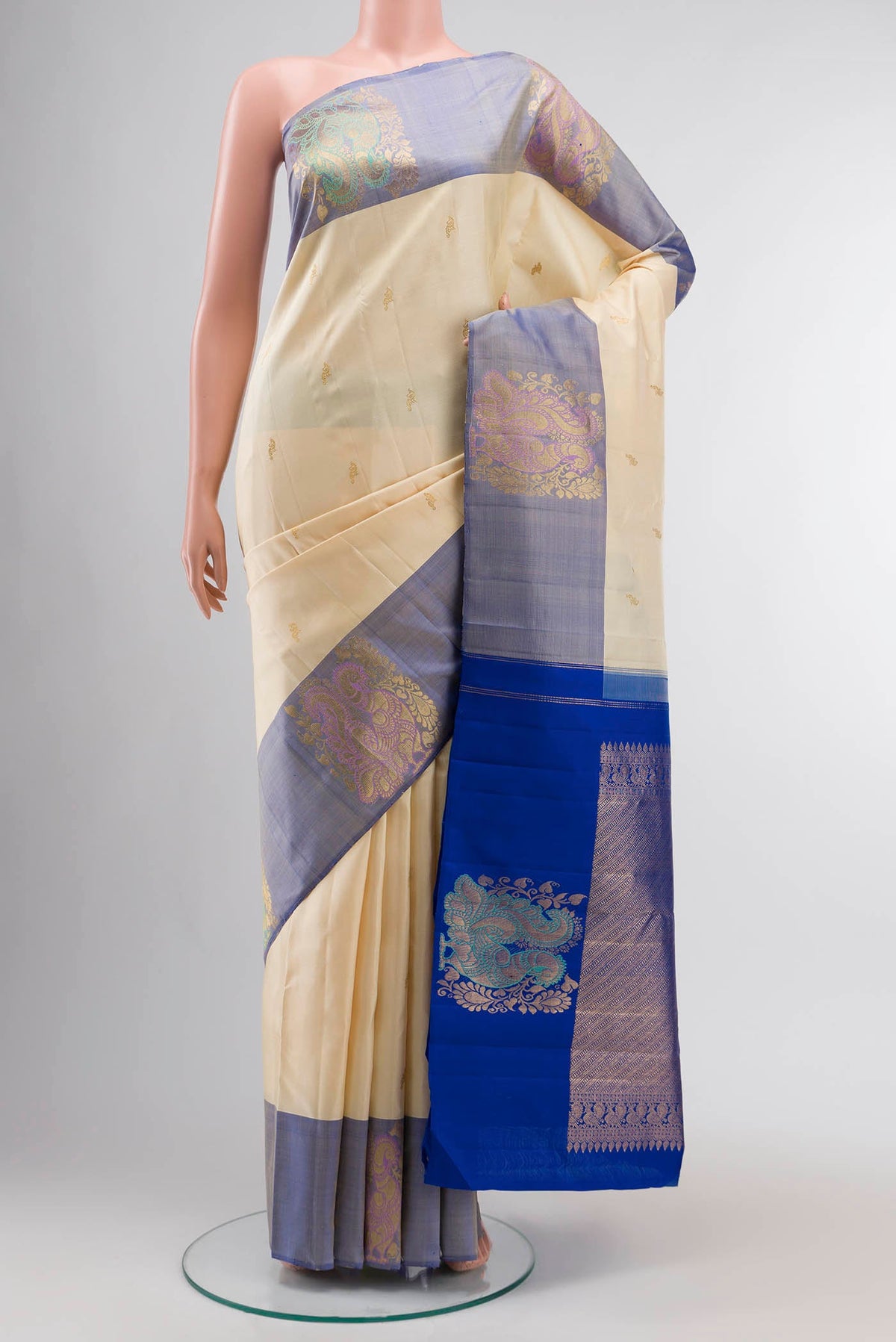 Cream Kanchipuram Silk Saree with Zari Butta on the body and Zari Border displayed on a mannequin