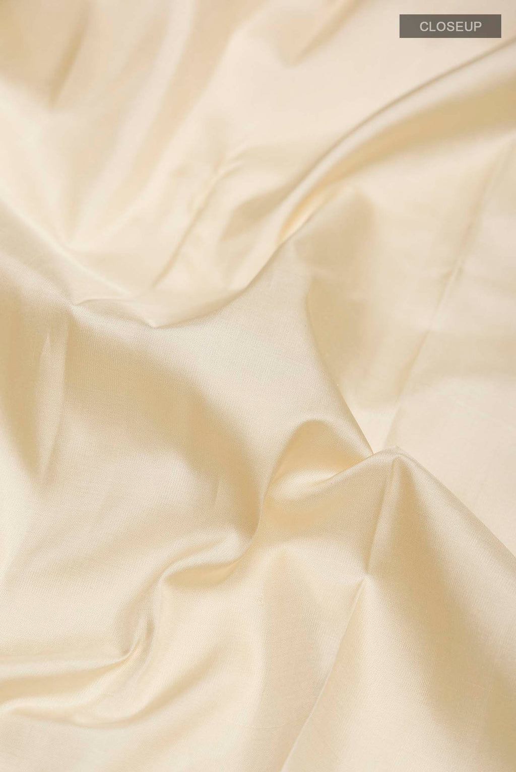 Close up of Cream Kanchipuram Silk Saree with Plain Body and Checks Border displaying folds