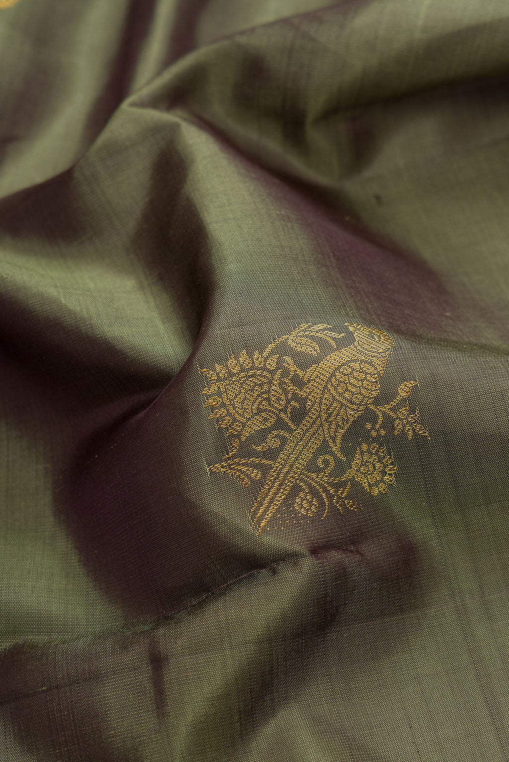 Close up of Mehandi Green Dual Tone Kanjivaram Silk Saree with Zari Butta on the body and Fancy Border.  displaying folds