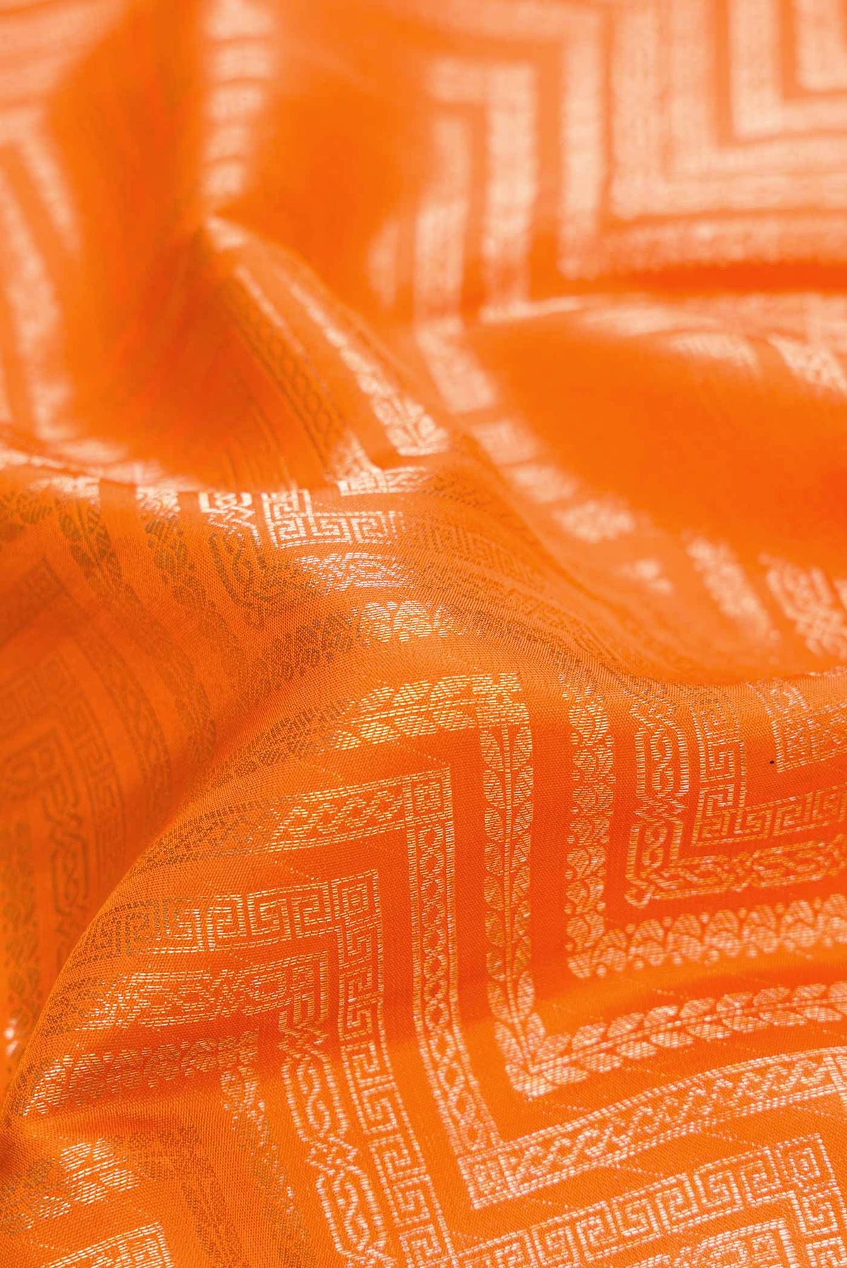 Close up of Orange Dual Tone Kanchipuram Silk Saree with Zari Brocade on the body and Zari Border.  displaying folds
