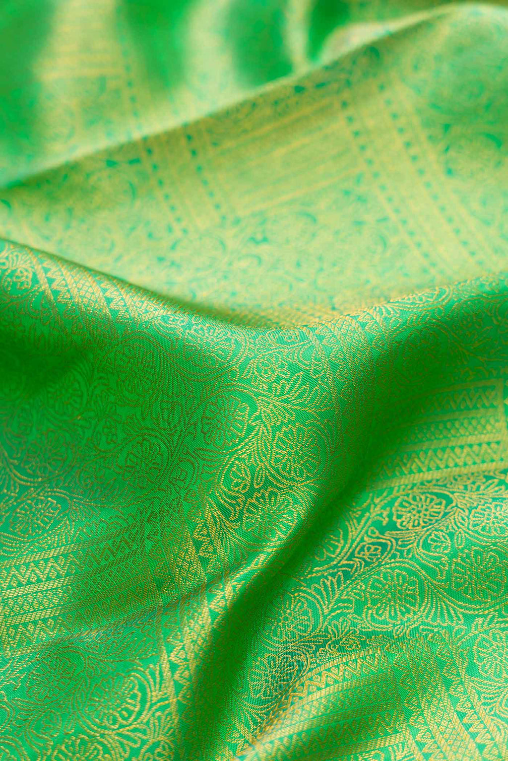 Close up of Parrot Green Dual Tone Kanchipuram Silk Saree with Zari Brocade on the body and Zari Border.  displaying folds
