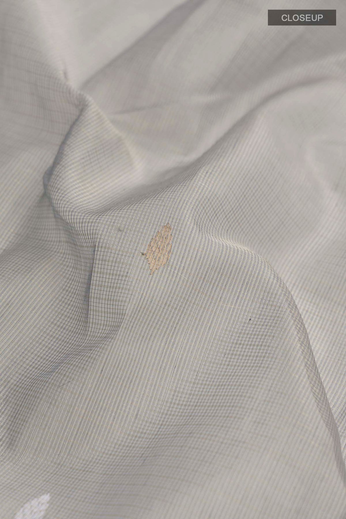 Close up of Grey Maheshwari Silk Cotton Saree with Zari Butta on the body and Zari Border displaying folds