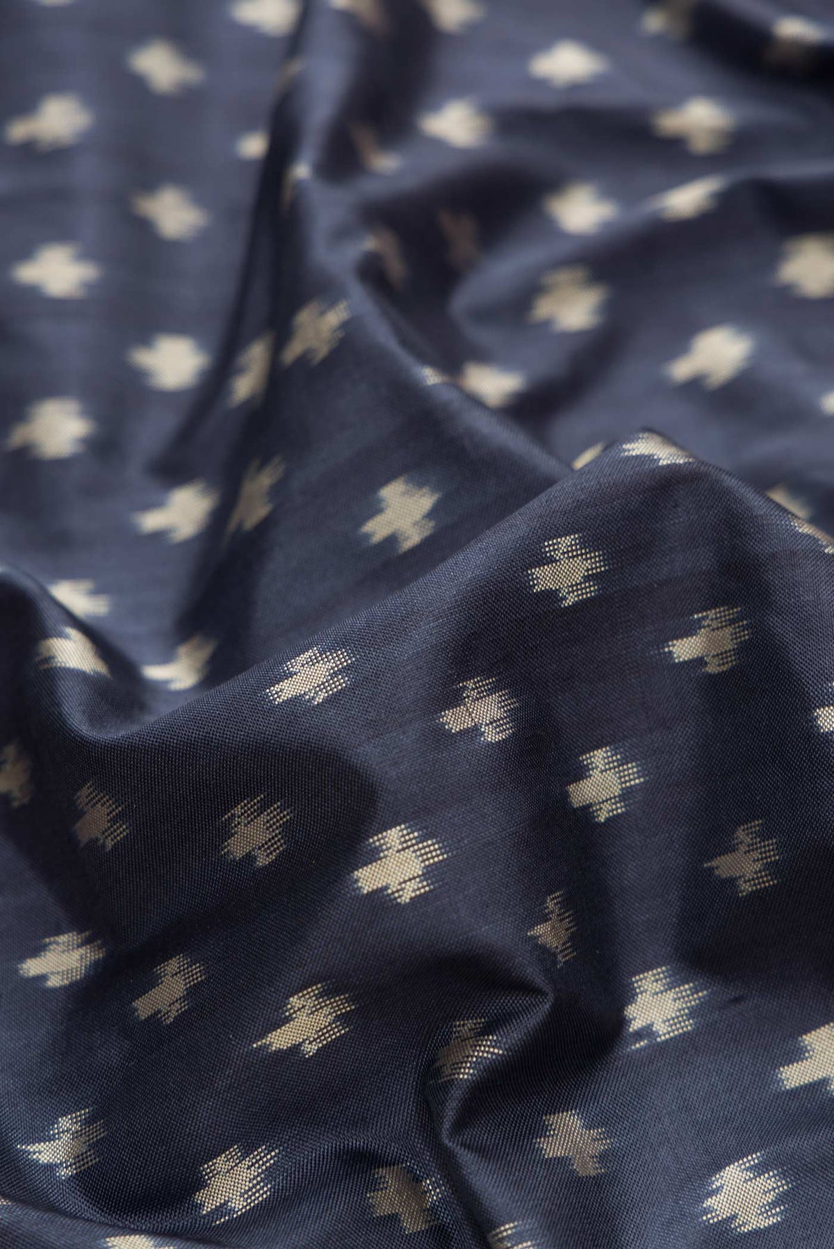 Close up of Navy Blue Dual Tone Double Ikat Saree with Ikat Print on the body and Zari Border.  displaying folds