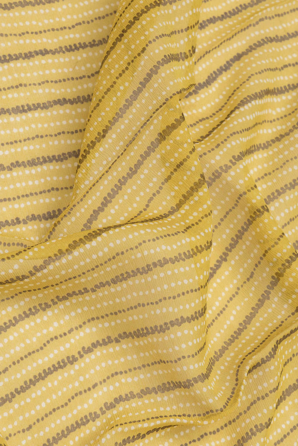 Close up of Mustard Dual Tone Mysore Chiffon Saree with Printed design on the body and Zari Border.  displaying folds