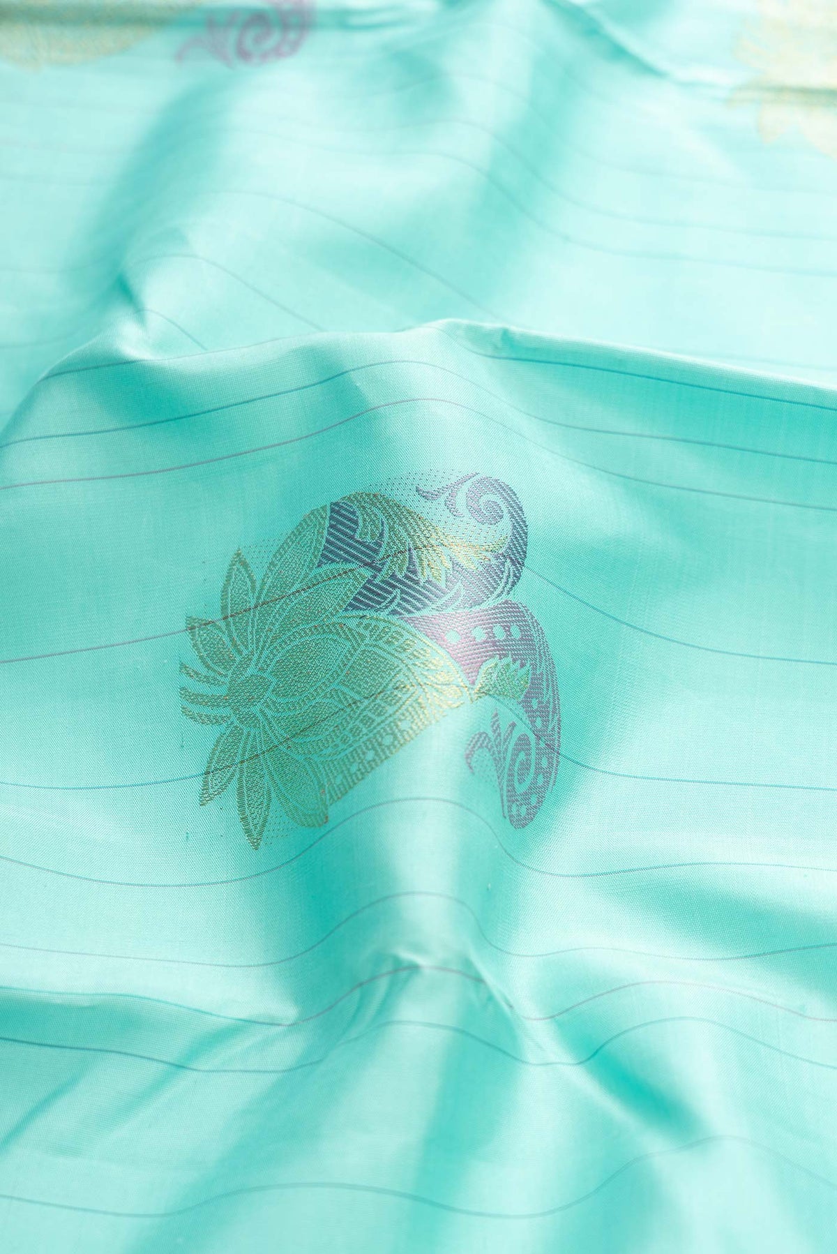 Close up of Sea Green Dual Tone Kanchipuram Silk Saree with Zari And Thread Butta on the body and Without Border displaying folds