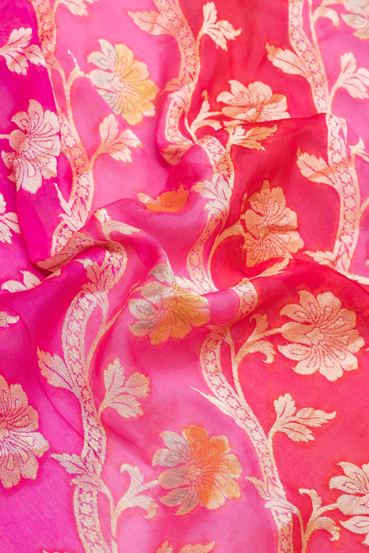 Close up of Pink Banarasi Georgette Saree with Zari And Thread Butta on the body and Zari Border.  displaying folds
