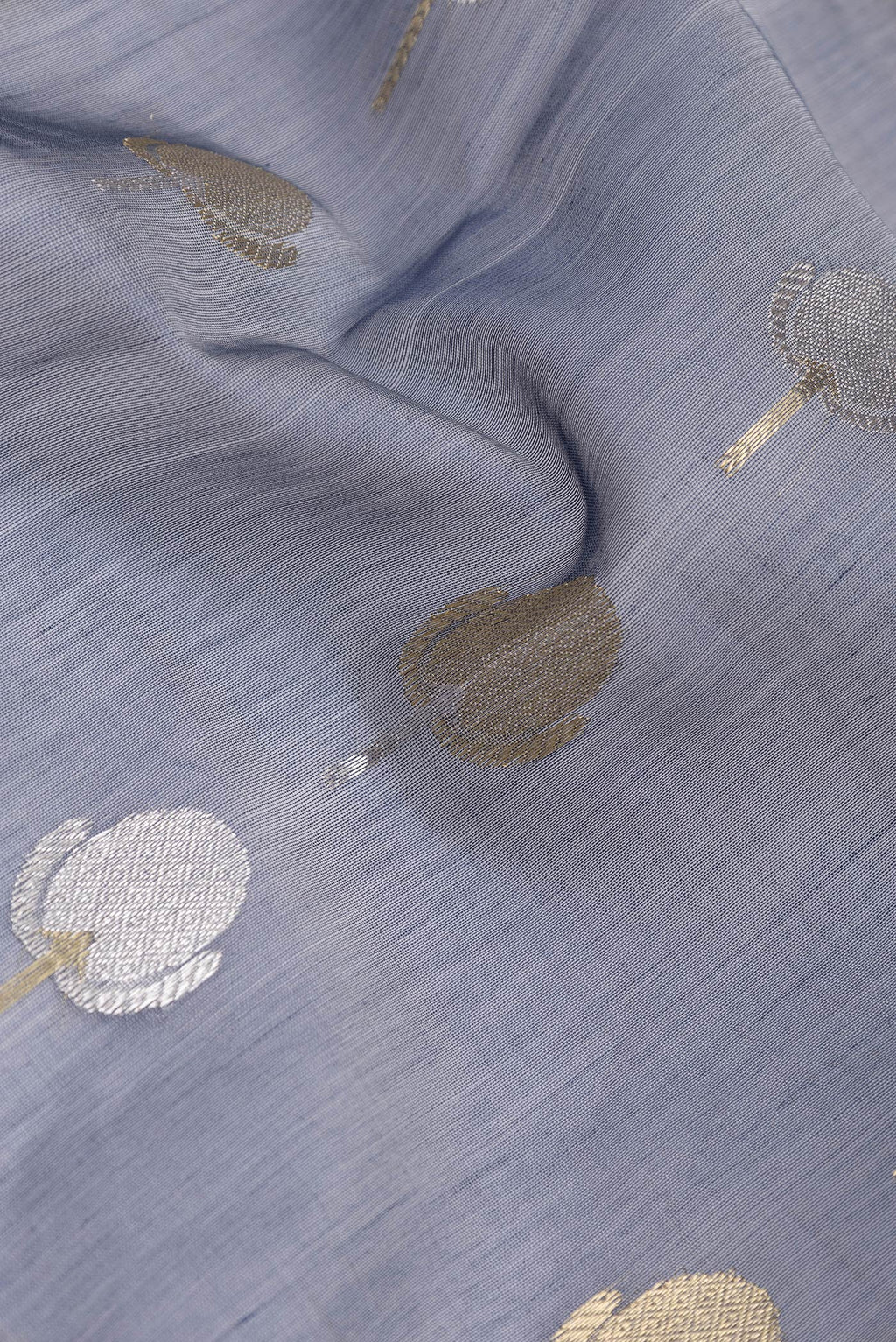 Close up of Grey Dual Tone Organza Silk Saree with Zari Butta on the body and Zari Border.  displaying folds