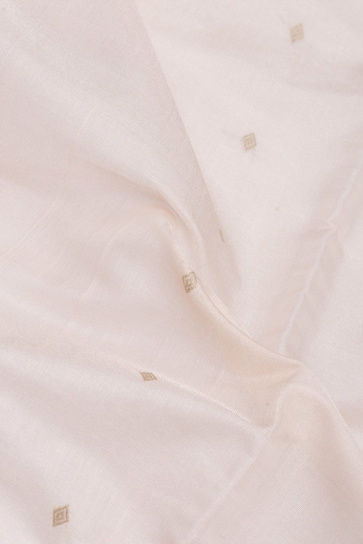 Close up of Rose Gold Dual Tone Tussar Silk Saree with Zari Butta on the body and Plain Border.  displaying folds