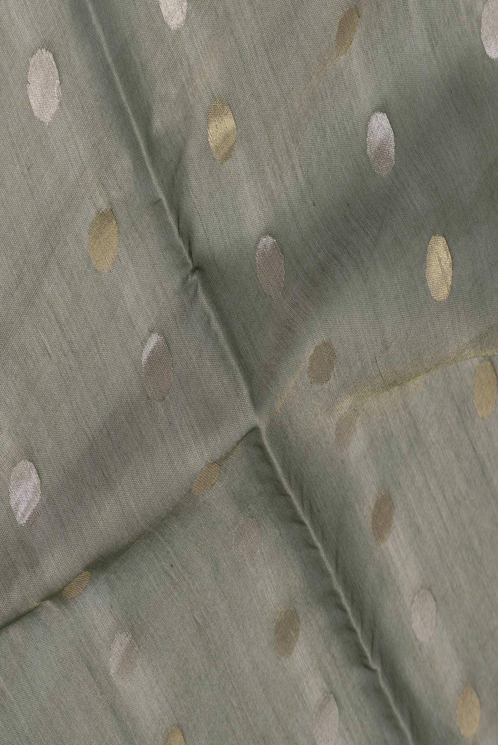 Close up of Bottle Green Dual Tone Chanderi Silk Saree with Zari Butta on the body and Thin Zari Line.  displaying folds