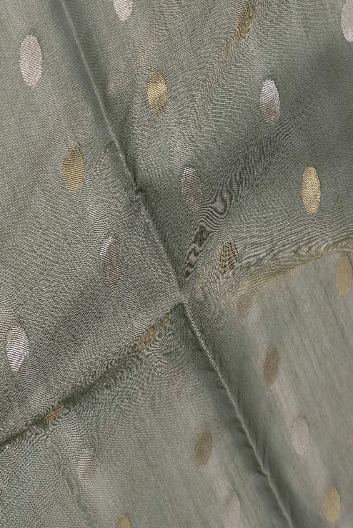 Close up of Bottle Green Dual Tone Chanderi Silk Saree with Zari Butta on the body and Thin Zari Line.  displaying folds