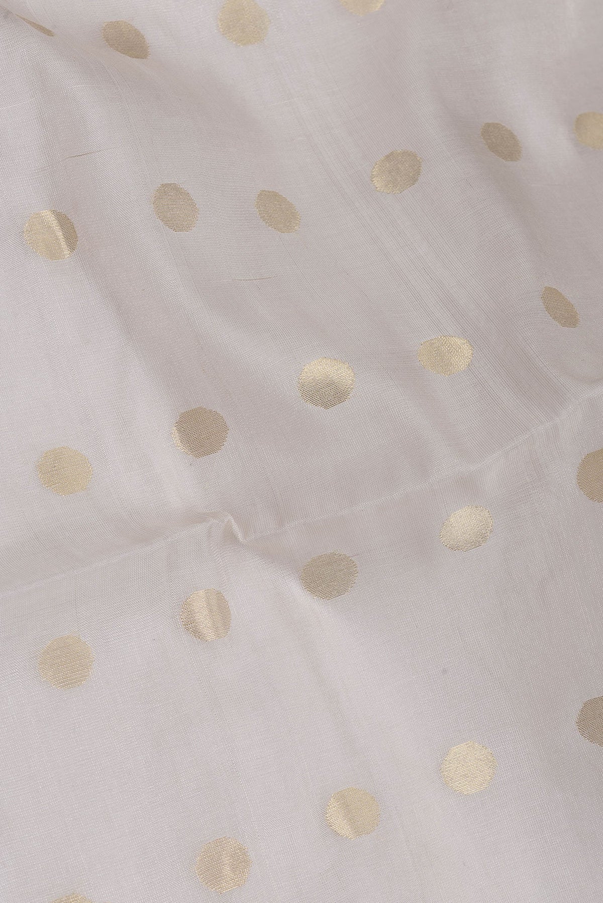 Close up of Beige Dual Tone Chanderi Silk Saree with Zari Butta on the body and Thin Zari Line.  displaying folds