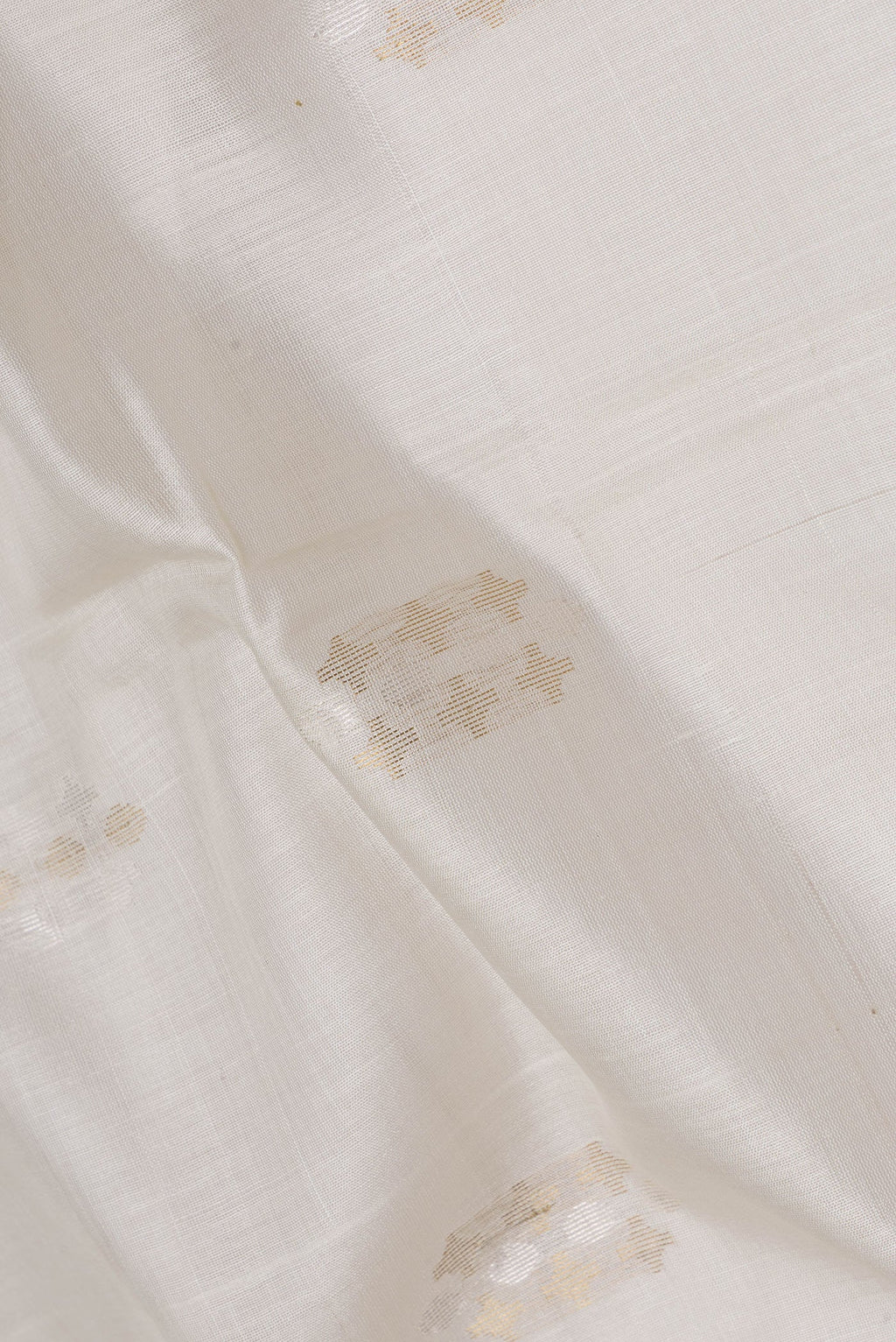Close up of Beige Dual Tone Tussar Silk Saree with Zari Butta on the body and Fancy Border.  displaying folds