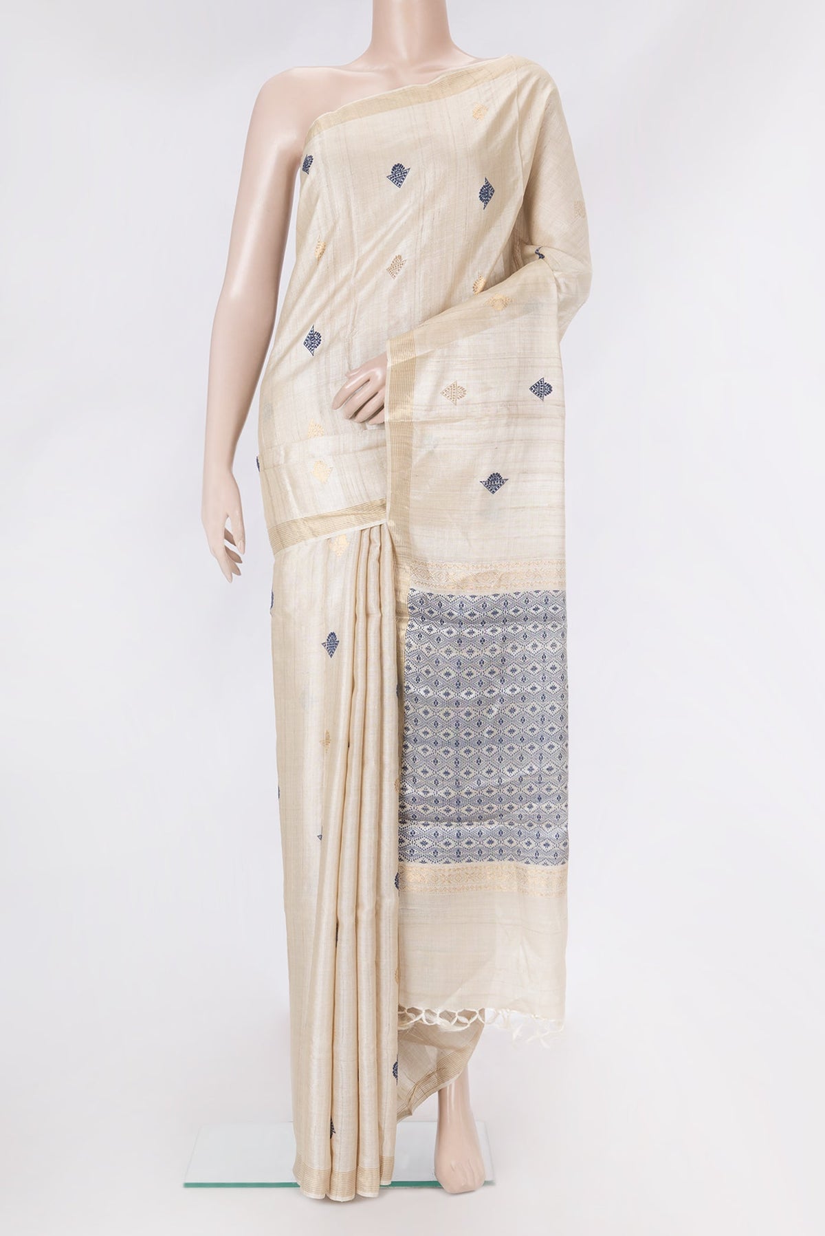 Beige Dual Tone Tussar Silk Saree with Zari And Thread Butta on the body and Zari Border.  displayed on a mannequin
