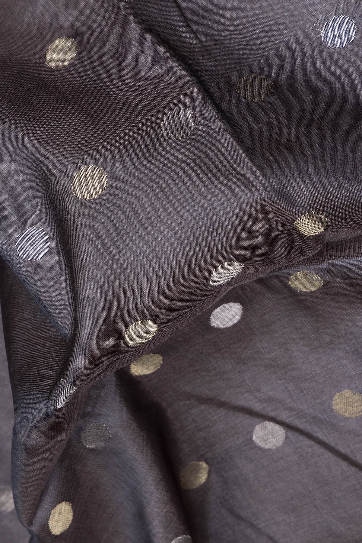 Close up of Grey Dual Tone Tussar Silk Saree with Zari Butta on the body and Zari Border.  displaying folds