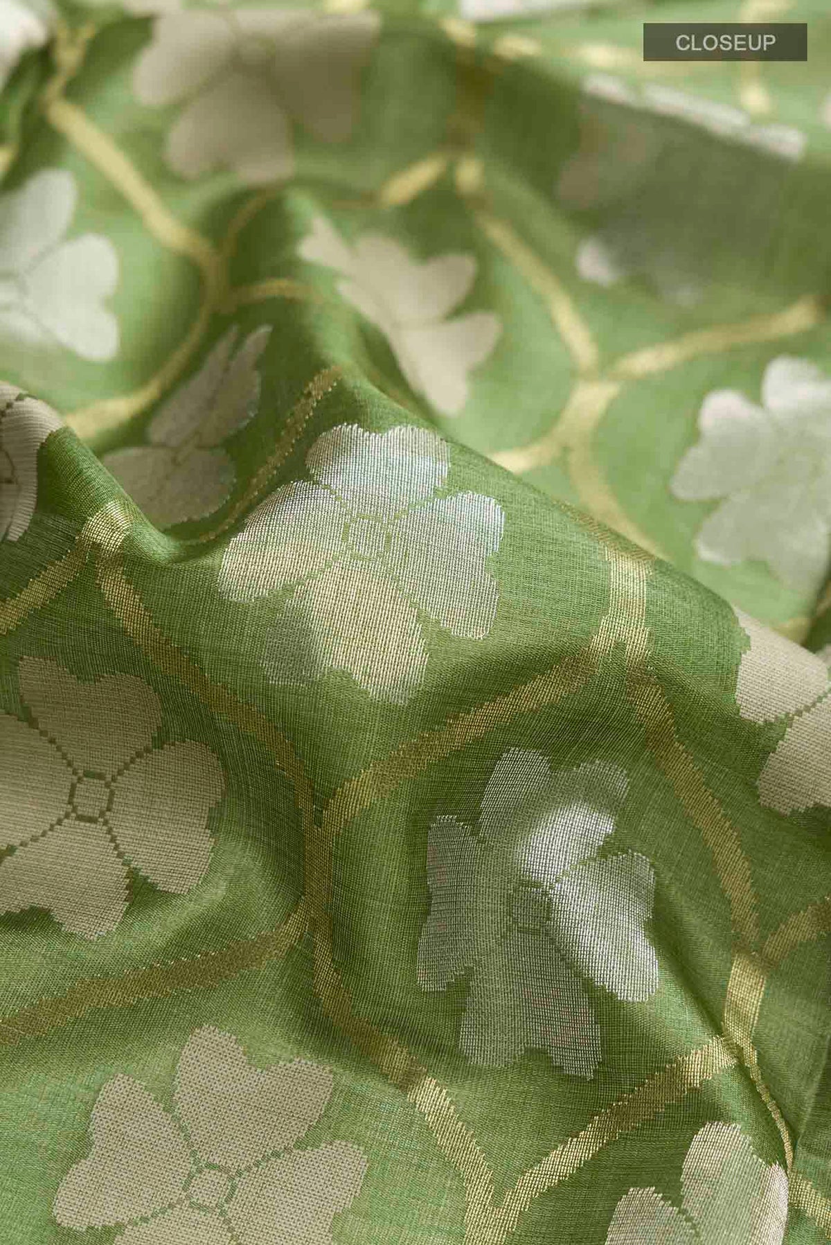 Close up of Green Tussar Silk Saree with Zari Butta on the body and Plain Border displaying folds