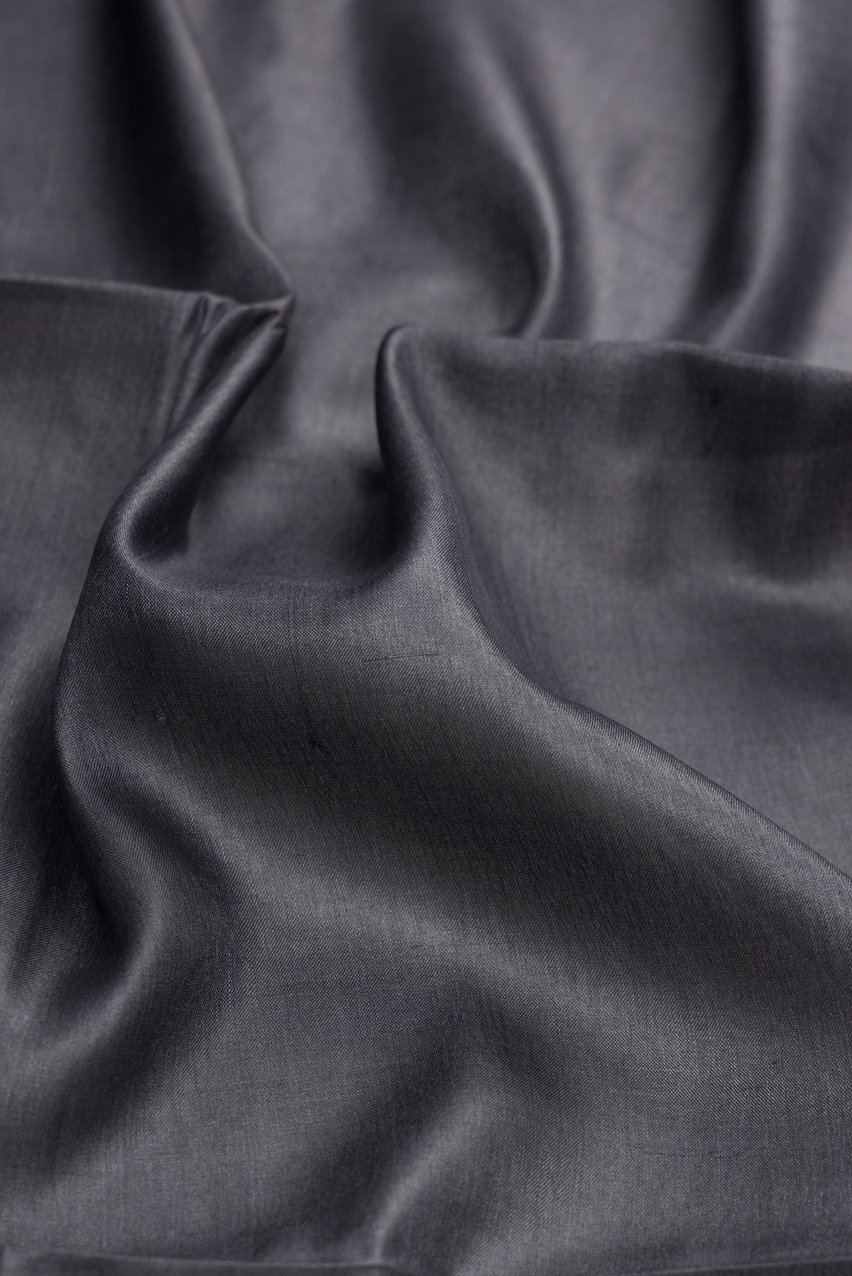 Close up of Grey Dual Tone Tussar Silk Saree with Plain Body and Fancy Border.  displaying folds