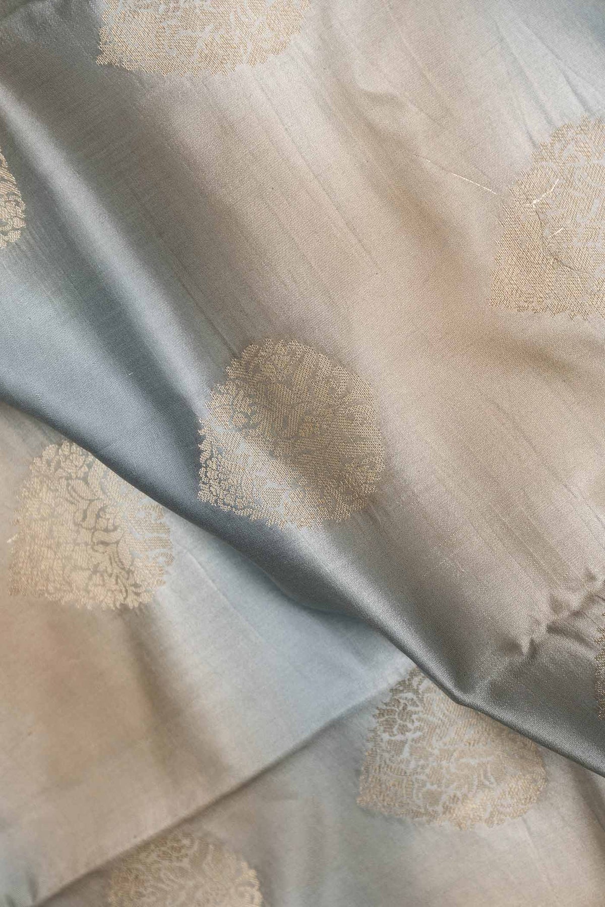 Close up of Multi Color Banarasi Raw Silk Saree with Zari Butta on the body and Zari Border displaying folds
