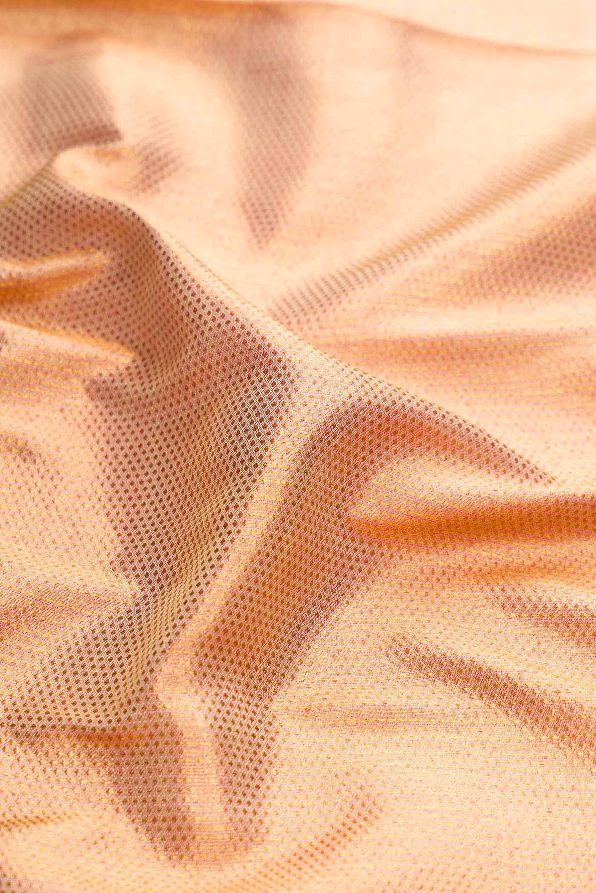 Close up of Golden Peach Dual Tone Kanchipuram Silk Saree with Zari Brocade on the body and Fancy Border displaying folds