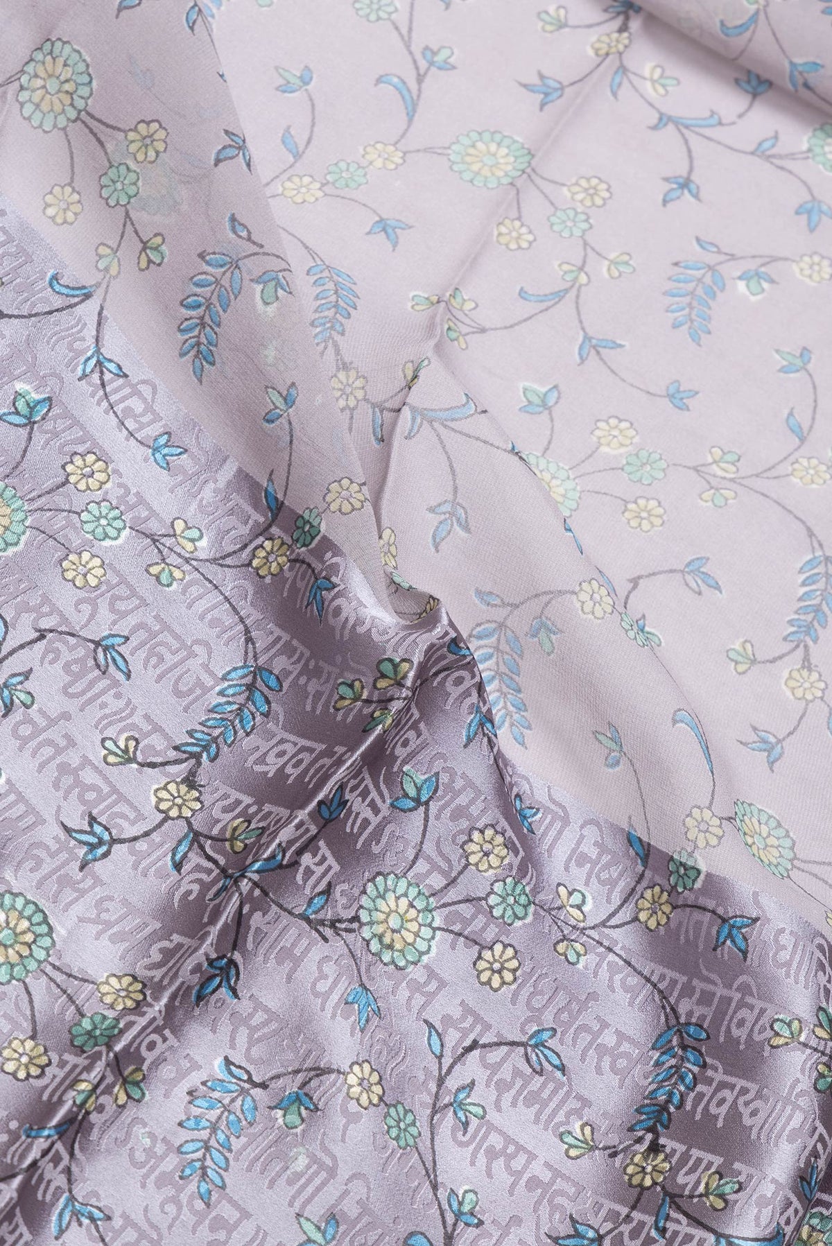 Close up of Grey Dual Tone Mysore Georgette Saree with Printed design on the body and Printed Border.  displaying folds