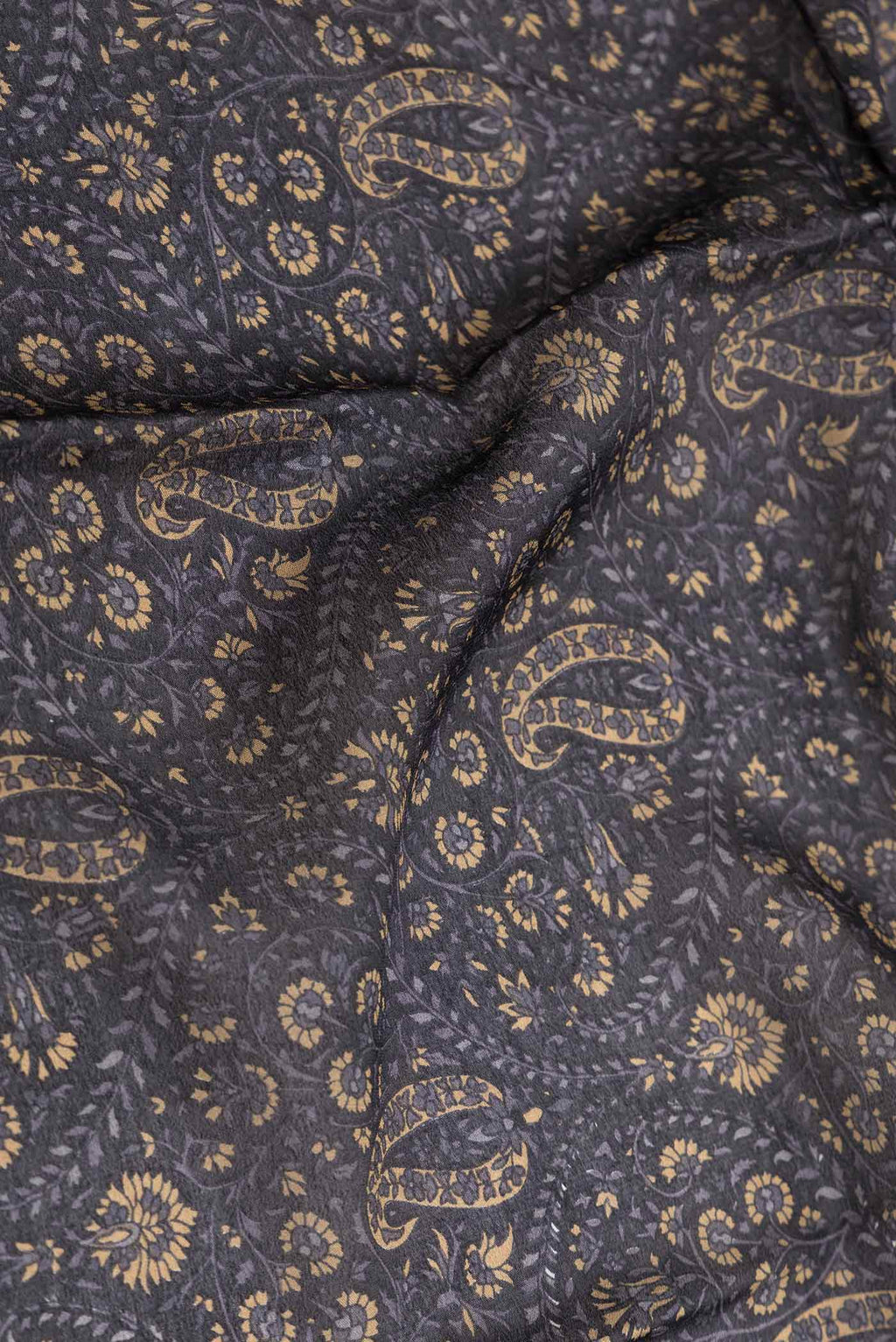 Close up of Black Dual Tone Mysore Crepe Saree with Printed design on the body and Zari Border displaying folds
