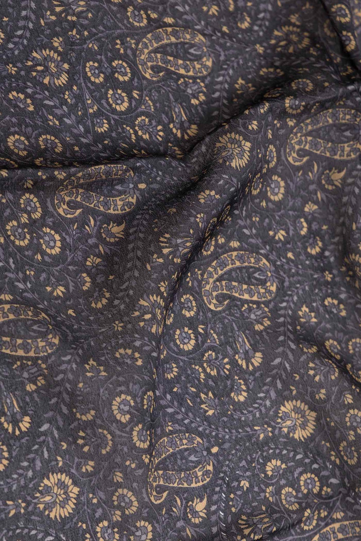 Close up of Black Dual Tone Mysore Crepe Saree with Printed design on the body and Zari Border displaying folds