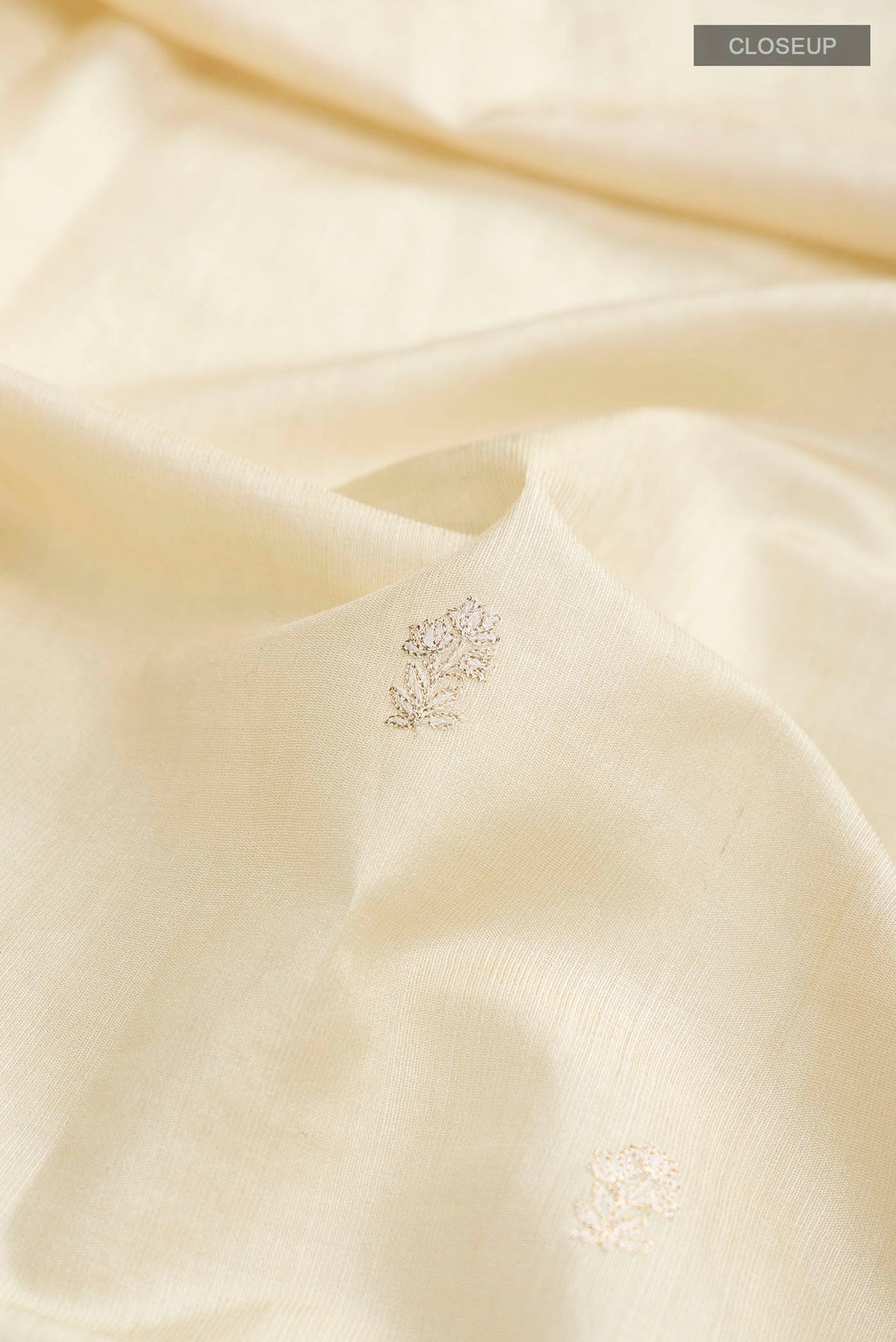 Close up of Cream Bhagalpuri Tussar Silk Saree with Embroidery on the body and Embroidery Border displaying folds