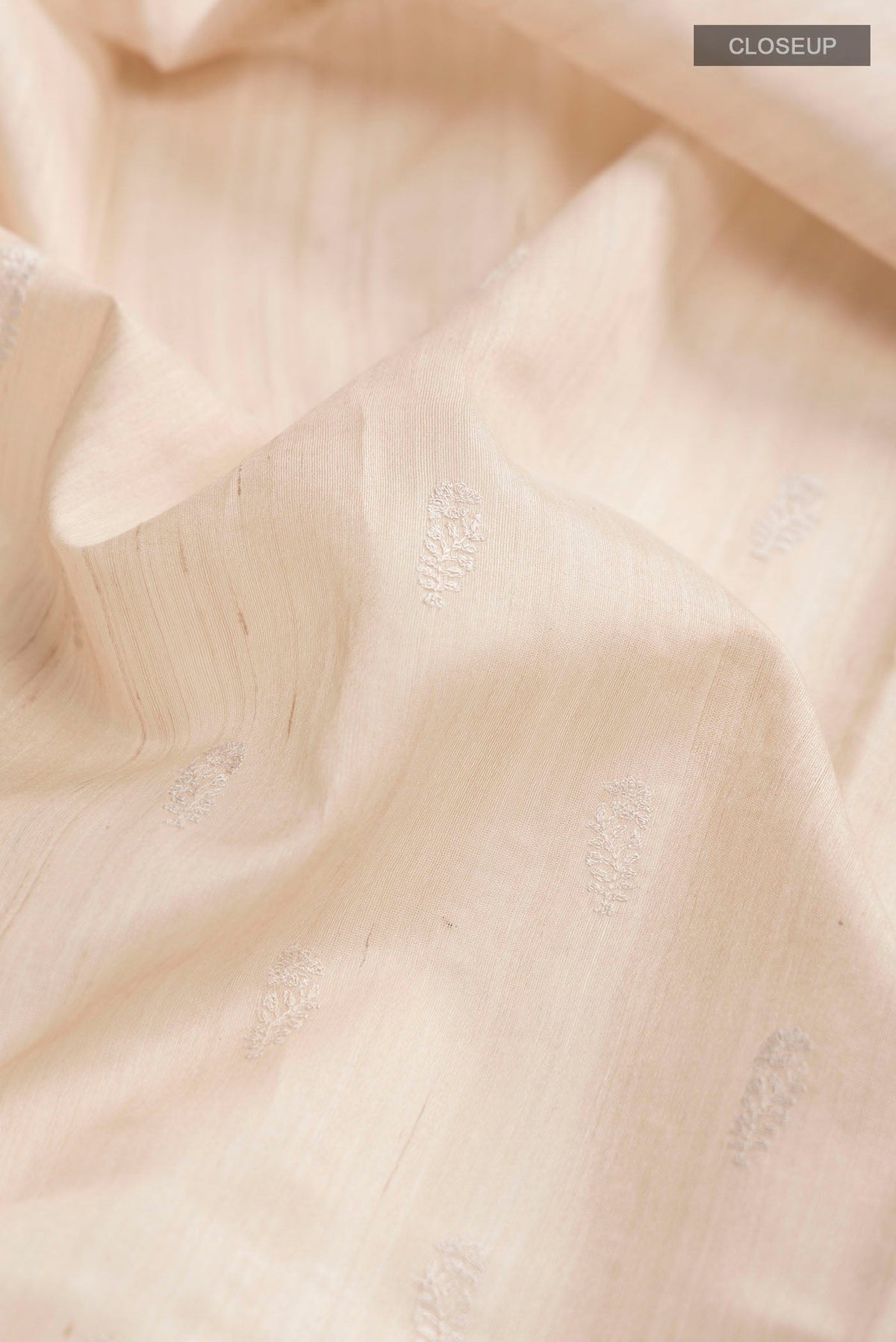 Close up of Beige Bhagalpuri Tussar Silk Saree with Embroidery on the body and Zari Border displaying folds