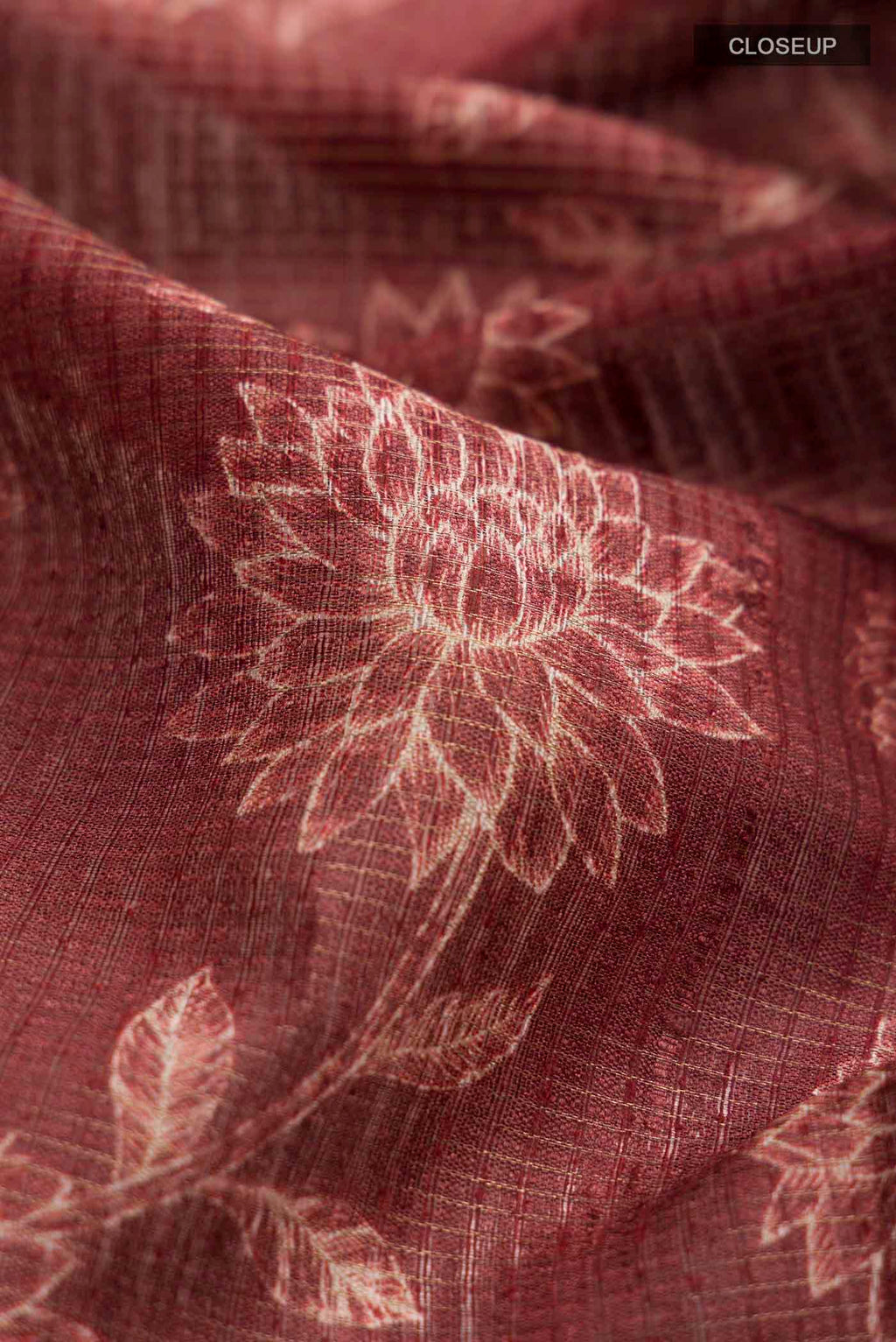 Close up of Maroon Tussar Silk Saree with Printed design on the body and Zari Border displaying folds