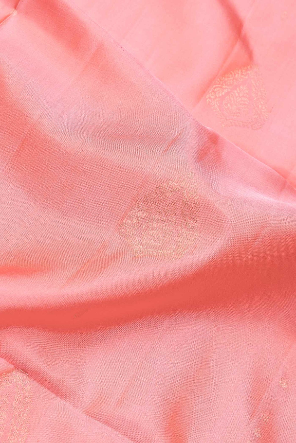Close up of Peach Dual Tone Soft Silk Saree with Zari Butta on the body and Zari Border.  displaying folds