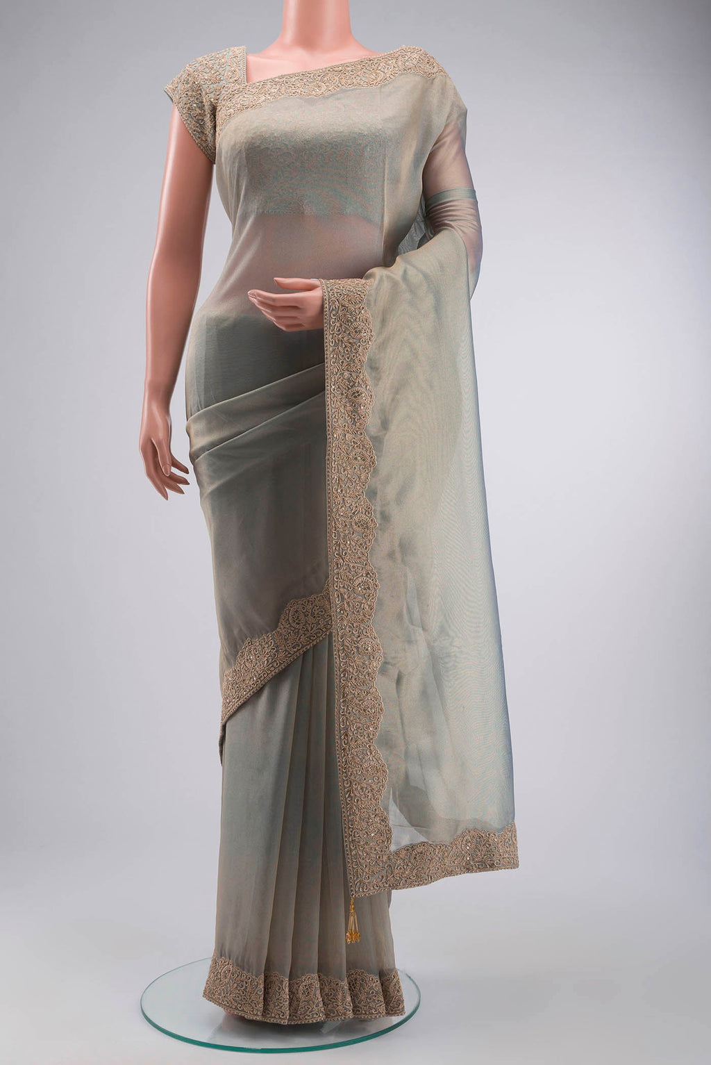 Green Tissue Silk Saree with Plain Body and Embroidery Border displayed on a mannequin
