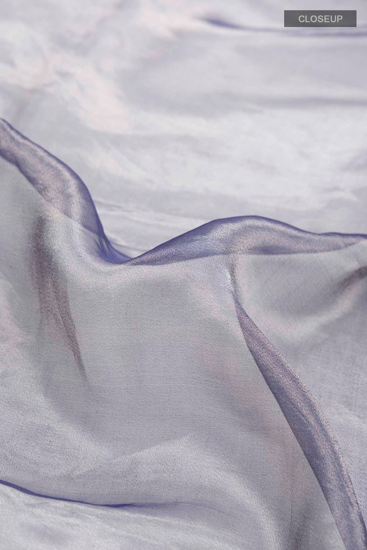 Close up of Lilac Tissue Silk Saree with Plain Body and Embroidery Border displaying folds