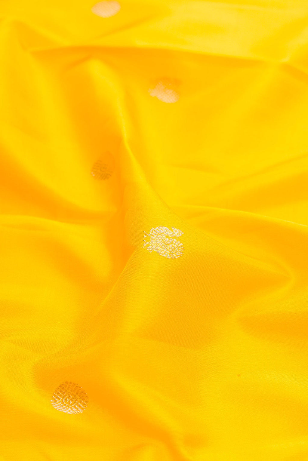 Close up of Yellow Dual Tone Kanchipuram Silk Saree with Zari Butta on the body and Temple Border displaying folds