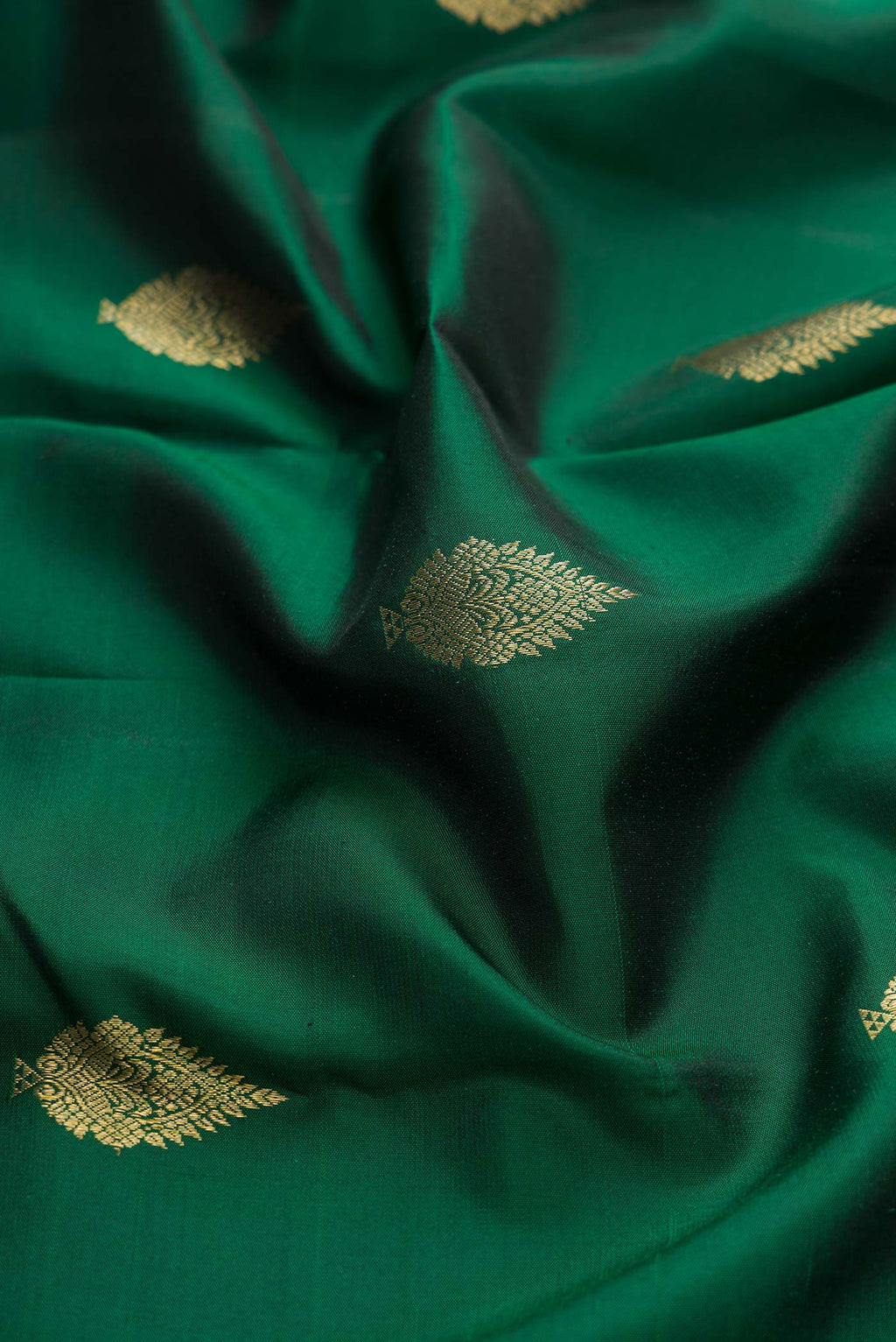 Close up of Green Dual Tone Kanchipuram Silk Saree with Zari Butta on the body and Zari Border displaying folds