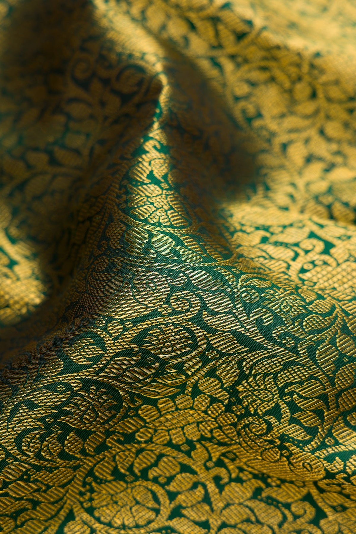 Close up of Bottle Green Dual Tone Kanjivaram Silk Saree with Zari Brocade on the body and Zari Border.  displaying folds