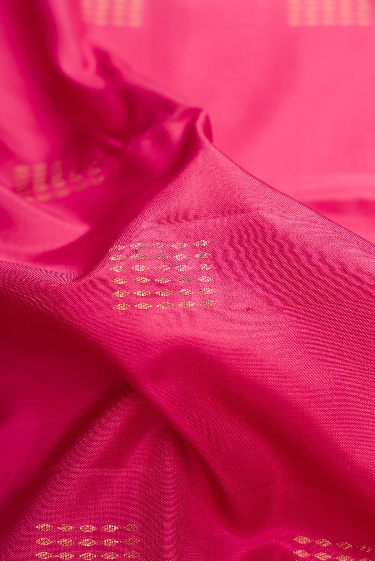 Close up of Pink Dual Tone Soft Silk Saree with Zari Butta on the body and Zari Border.  displaying folds